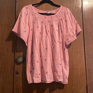 Babydoll style pink embroidered flowered blouse.